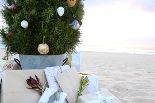 Decorated Christmas tree with presents at beach - Australian Stock Image