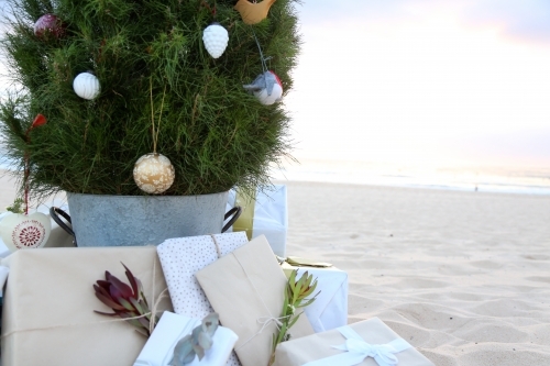 Decorated Christmas tree with presents at beach