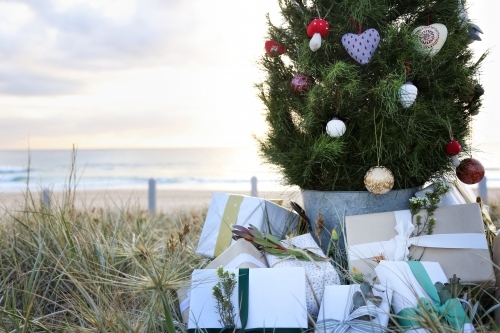 Decorated Christmas tree with presents at beach - Australian Stock Image