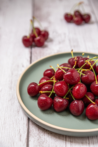 wet red cherries on a plate - Australian Stock Image