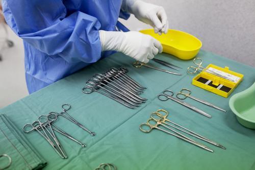 Detail of a theatre nurse preparing equipment for surgery in a hospital operating theatre - Australian Stock Image