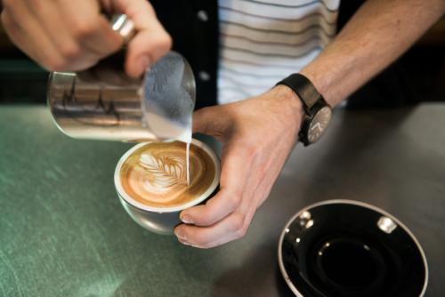 Detail of barista making coffee inside a cafe