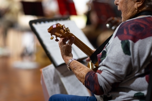 detail of elderly lady playing ukulele - Australian Stock Image