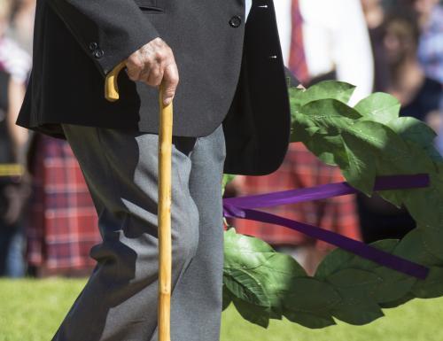 Detail of elderly male digger laying a wreath on ANZAC Day