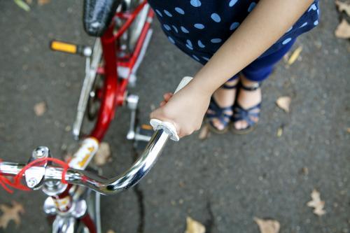 Detail of girl holding bike handle from above - Australian Stock Image