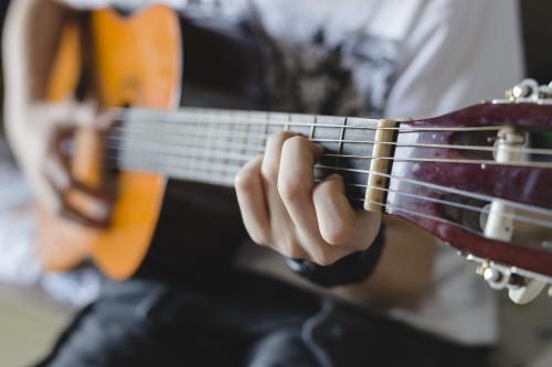 Detail of teenage Boy playing guitar