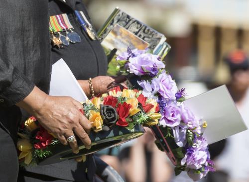 Detail of two people carrying a wreath on ANZAC Day