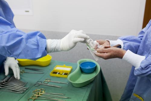 Detail of two theatre nurses preparing equipment for surgery in a hospital operating theatre - Australian Stock Image