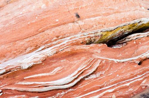 Detail shot of layered and patterned rock with orange, pink and yellow colours - Australian Stock Image
