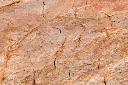 Detail shot of pink and orange rock with texture, patterns and cracks