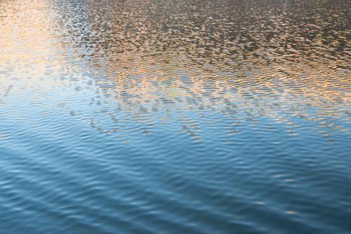 Detail shot of water with ripples and blue and orange tones - Australian Stock Image