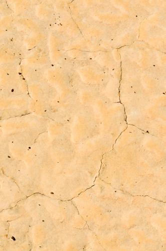 Detail shots of yellow patterned desert claypans with cracks - Australian Stock Image