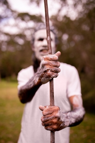 Dharawal man with a painted face holding a spear