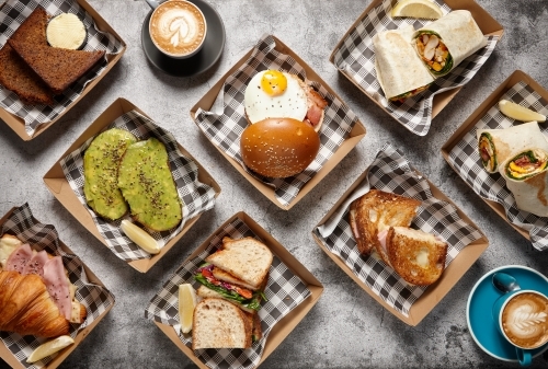 Different types of sandwiches on takeaway containers with a cup of coffee - Australian Stock Image
