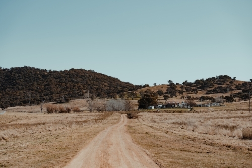 Dirt road driveway leading to a grassy rural property. - Australian Stock Image