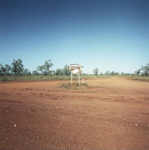 Dirt road in remote town with large metal letterbox