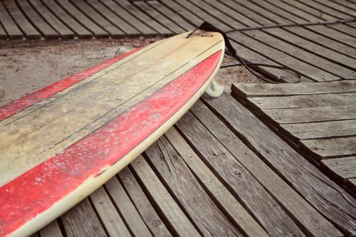 Dirty surfboard on wooden planking