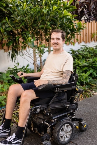 disabled man in motorised wheelchair, in carpark - Australian Stock Image