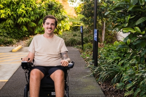 disabled man in motorised wheelchair, in carpark