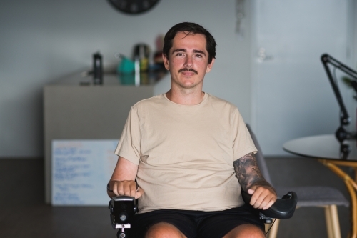 disabled man in wheelchair at home - Australian Stock Image