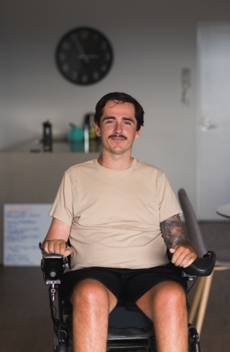 disabled man in wheelchair at home - Australian Stock Image