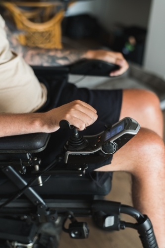 disabled man operating motorised wheelchair - Australian Stock Image