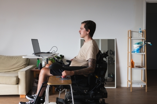disabled man using computer, with special adaptive devices - Australian Stock Image