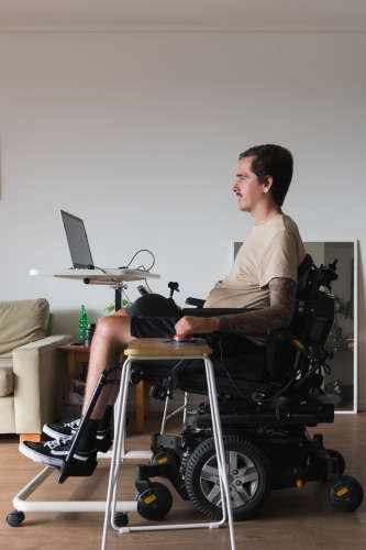 disabled man using computer, with special adaptive devices - Australian Stock Image