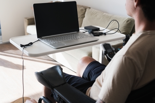 disabled man using computer, with special adaptive devices - Australian Stock Image