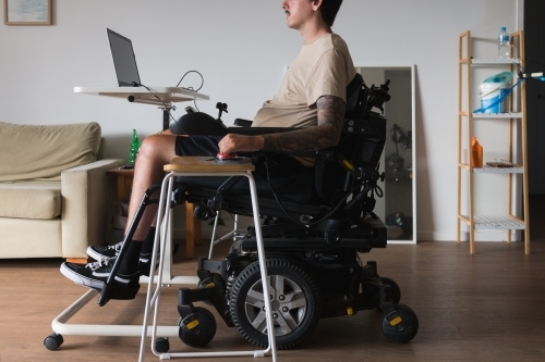 disabled man using computer, with special adaptive devices - Australian Stock Image