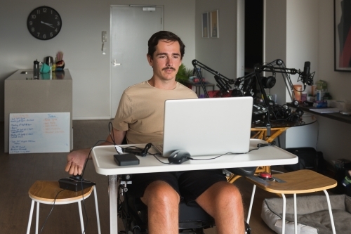 disabled man using computer, with special adaptive devices - Australian Stock Image