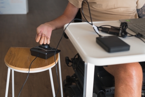 disabled man using computer, with special adaptive devices - Australian Stock Image