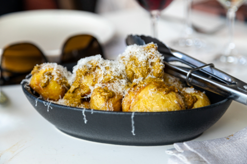 dish of potatoes with dressing and cheese - Australian Stock Image