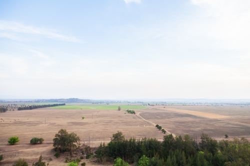 Distant paddock landscape with smokey sky - Australian Stock Image