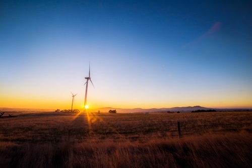 Distant wind turbines on a wind farm at sunrise. - Australian Stock Image