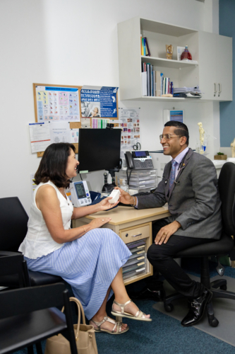 Doctor handing prescription medicine to female patient - Australian Stock Image