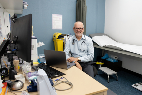 Doctor in office working at laptop - Australian Stock Image