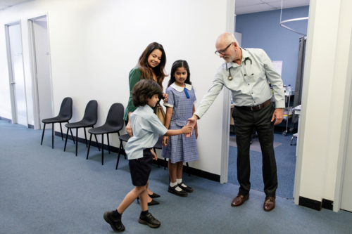 Doctor meeting family outside office - Australian Stock Image