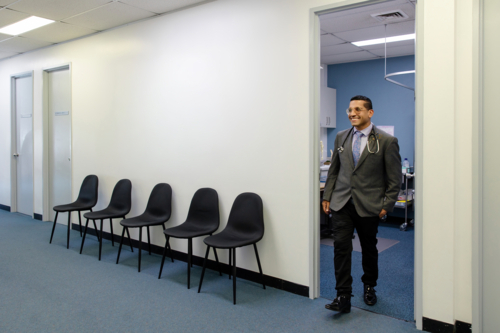 Doctor walking out of the door of the exam room - Australian Stock Image