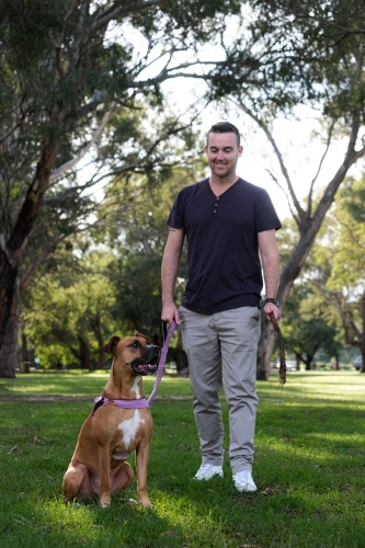 Dog and man looking at each other during walk in the park - Australian Stock Image