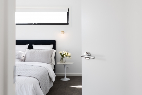 Door opening to reveal a luxury master bedroom - Australian Stock Image