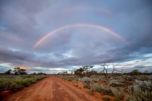 double rainbow over red dirt road - Australian Stock Image