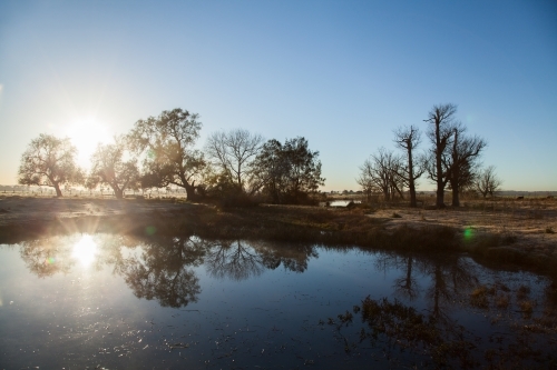 Double sunrise reflected in a farm dam - Australian Stock Image