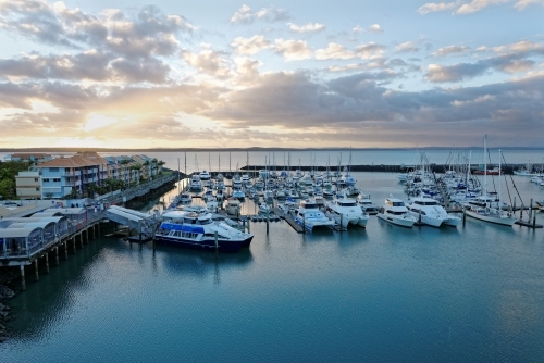 Dramatic clouds at dawn catching the light on the water Hervey Bay marina
