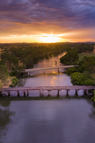 Dramatic colourful sunset over bridges on an inland river - Australian Stock Image