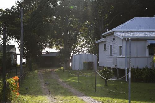 Driveway leading past weatherboard cottage - Australian Stock Image