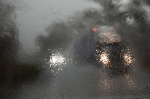 driving through heavy rain with passing trucks and cars - Australian Stock Image