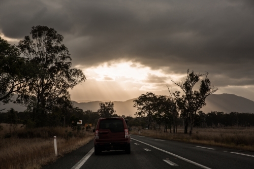 driving up the Bruce Highway in Central Queensland towards the sun peeking through clouds