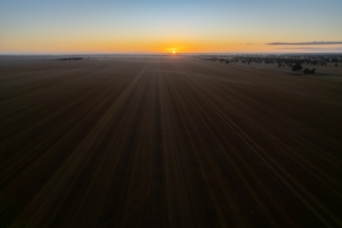 Drone shot of low sun over empty field - Australian Stock Image