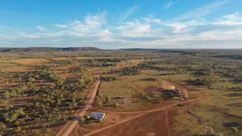 Drone shot of rural landscape, road and trucks loading cattle - Australian Stock Image